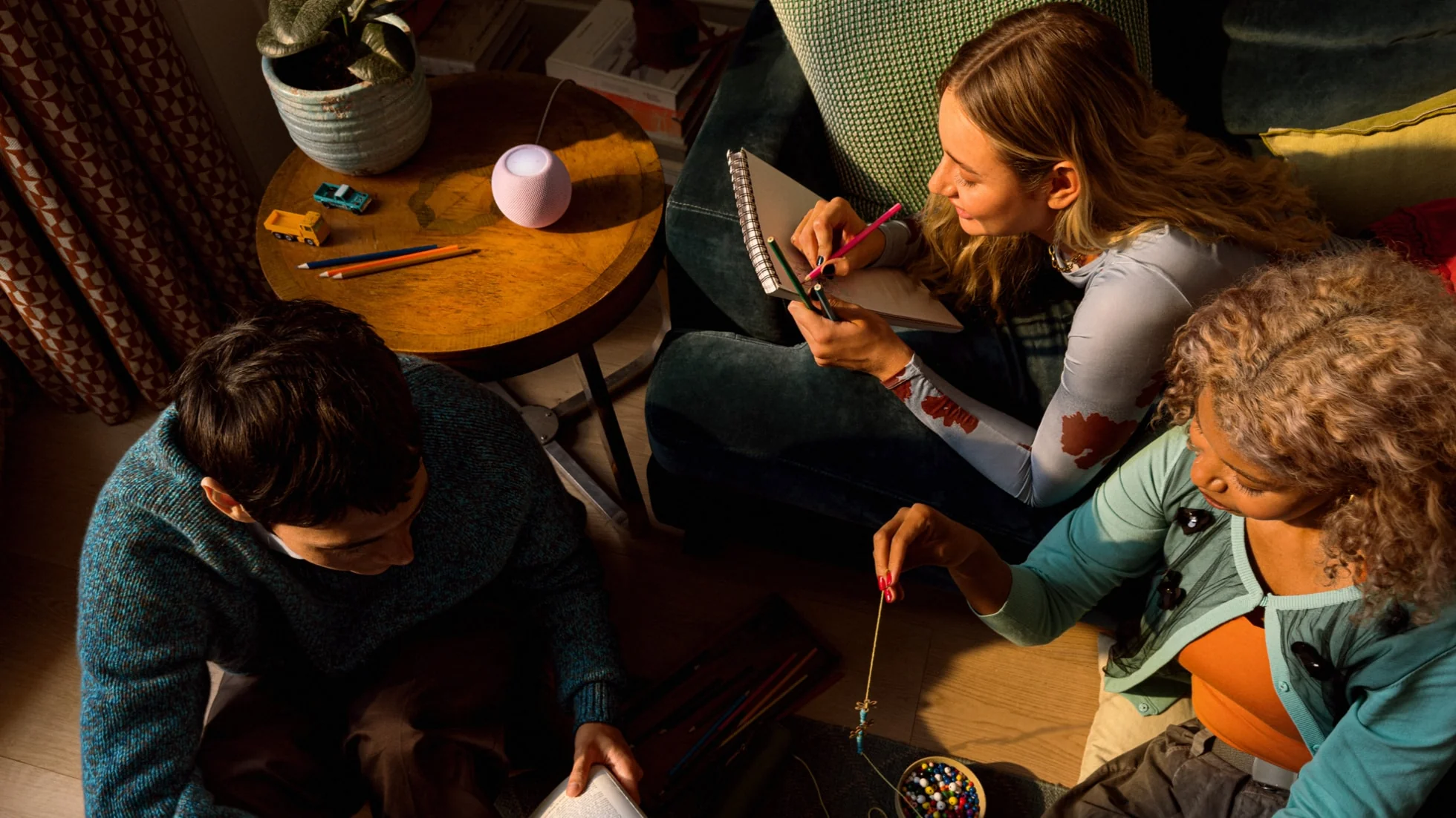 A group relaxes with HomePod mini 2 in the background